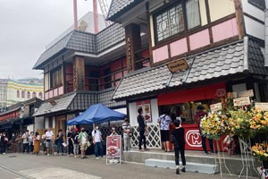 ドムドムハンバーガー浅草花やしき店グランドオープン。 お客様のご案内をする藤﨑社長。